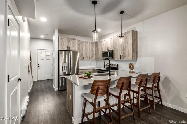 a kitchen with refrigerator a sink dishwasher a stove and a refrigerator with wooden floor