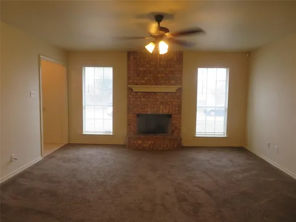 an empty room with a window and fireplace