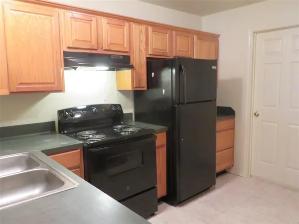 a kitchen with stainless steel appliances granite countertop a refrigerator and a stove