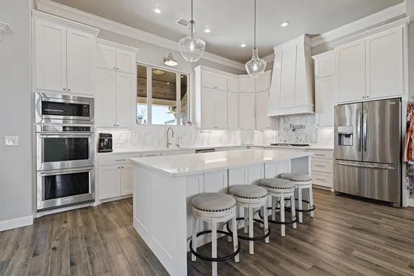a large white kitchen with cabinets a sink and dishwasher