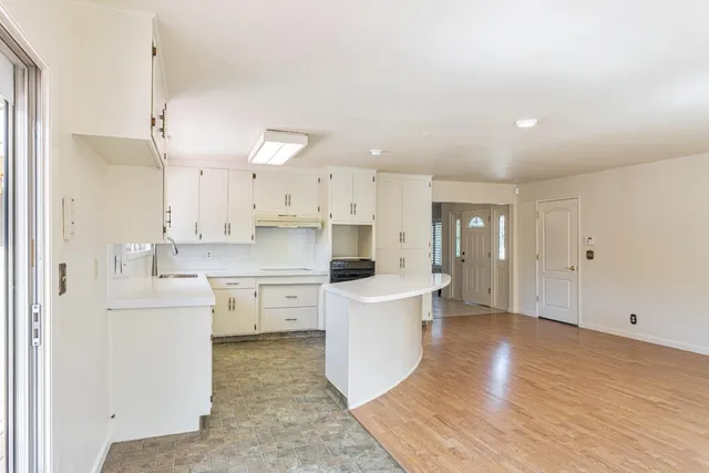 a open kitchen with white cabinets and white appliances
