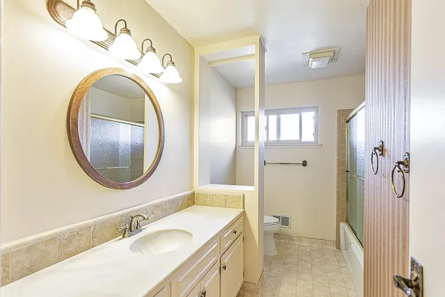 a bathroom with a granite countertop sink and a mirror