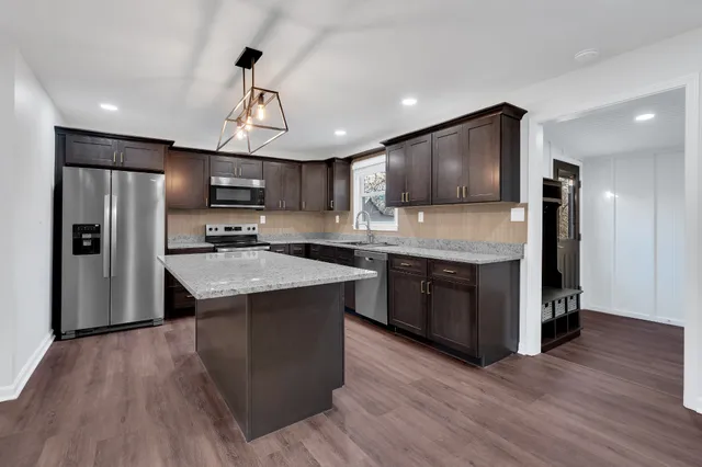 a kitchen with stainless steel appliances a sink a stove a refrigerator and cabinets
