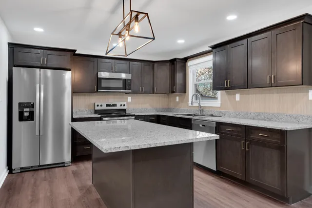 a kitchen with stainless steel appliances a sink stove and microwave