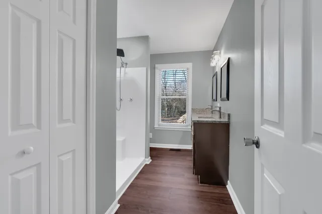 a bathroom with a granite countertop sink a toilet and shower