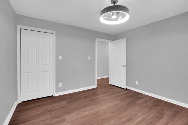a view of a hallway with wooden floor and staircase