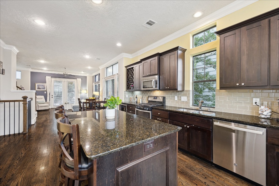 1110 West 25th Street Houston, TX 77008 - Photo 11 of 40 a kitchen with kitchen island granite countertop a stove a sink a dining table and chairs