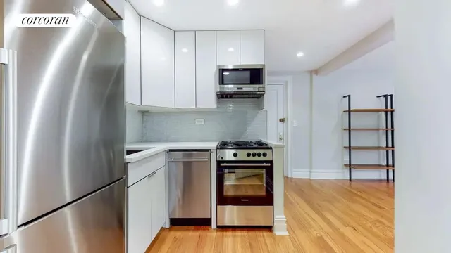 a kitchen with stainless steel appliances granite countertop a refrigerator and a stove top oven