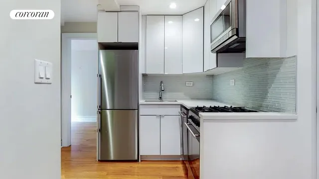a kitchen with stainless steel appliances granite countertop a refrigerator a stove and a sink