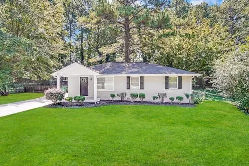 a front view of a house with a garden