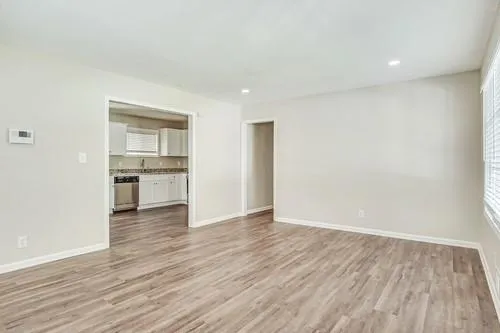 a view of empty room with wooden floor