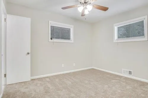 a view of an empty room and chandelier fan
