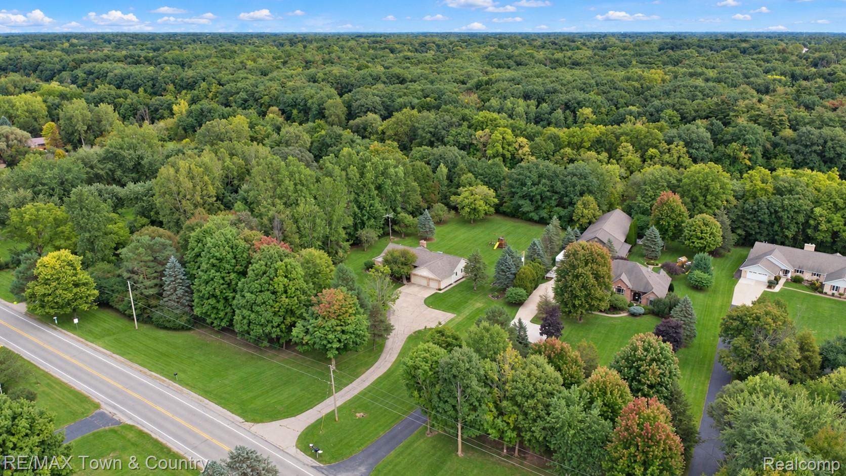 5464 North Seymour Road Flushing, MI 48433 - Photo 40 of 45 Expansive property featuring a paved road, paved driveways, a rich green lawn, and mature trees