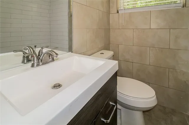 a bathroom with a sink a toilet and mirror