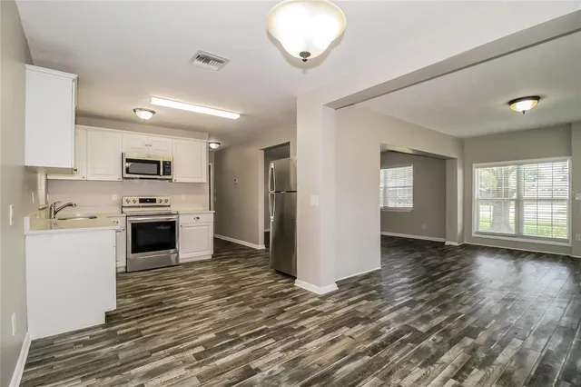 a kitchen with granite countertop a stove top oven and cabinets