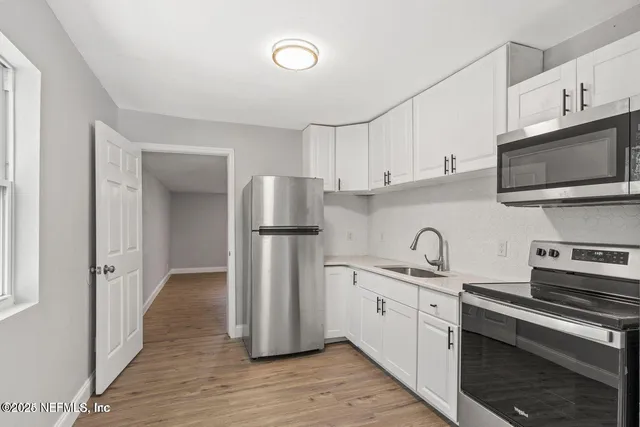 a kitchen with stainless steel appliances granite countertop a refrigerator sink and microwave