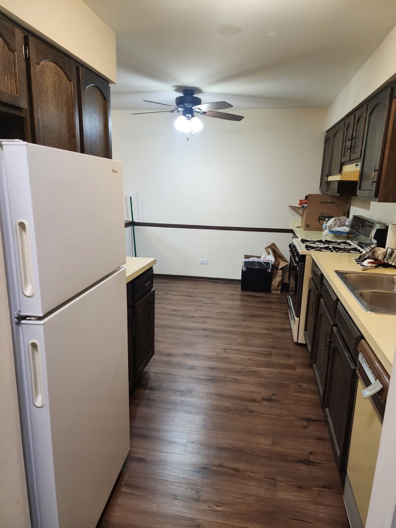 235 North Mill Road, Unit 106B Addison, IL 60101 - Photo 9 of 22 a kitchen with sink cabinets and wooden floor