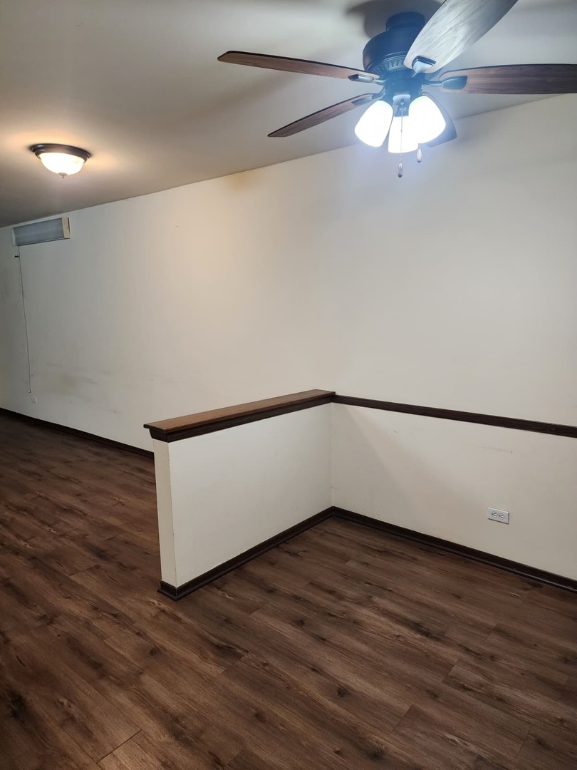 235 North Mill Road, Unit 106B Addison, IL 60101 - Photo 10 of 22 a view of an empty room with wooden floor and a window