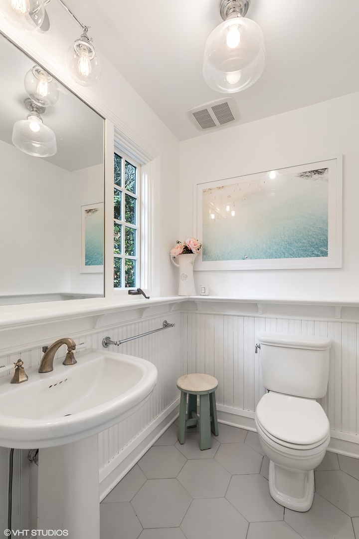 9 Warwick Road Winnetka, IL 60093 - Photo 26 of 54 a bathroom with a sink a toilet and mirror