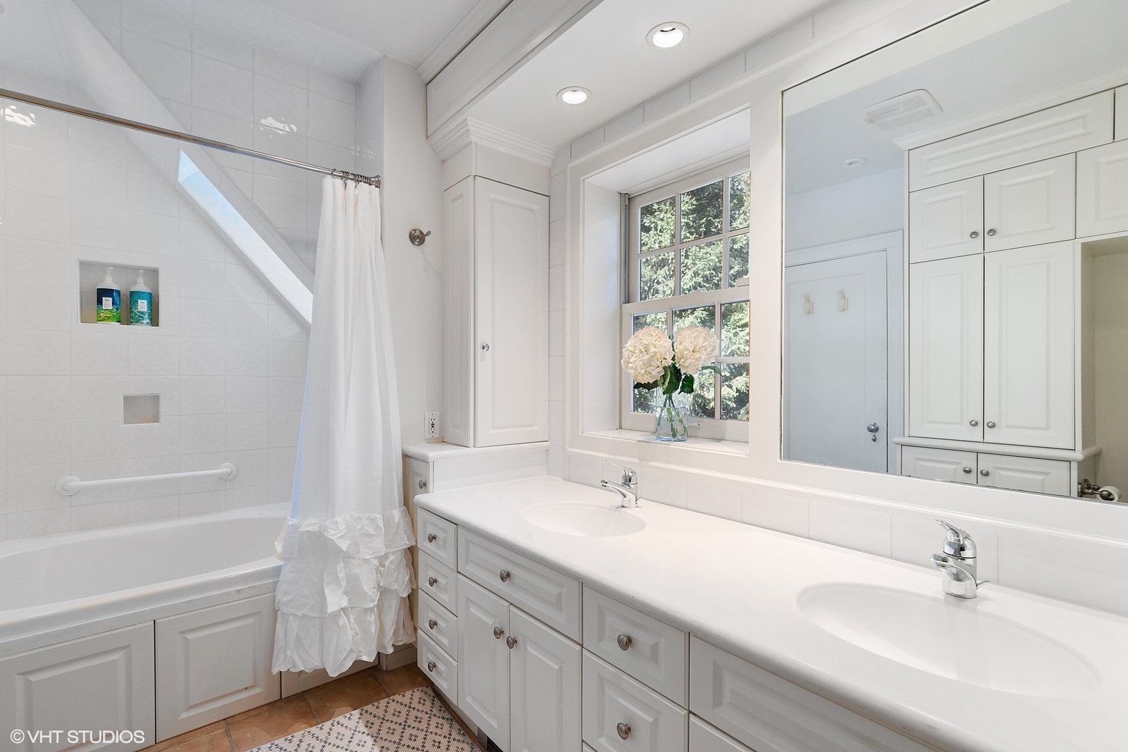 9 Warwick Road Winnetka, IL 60093 - Photo 33 of 54 a bathroom with a double vanity sink a mirror and a bathtub
