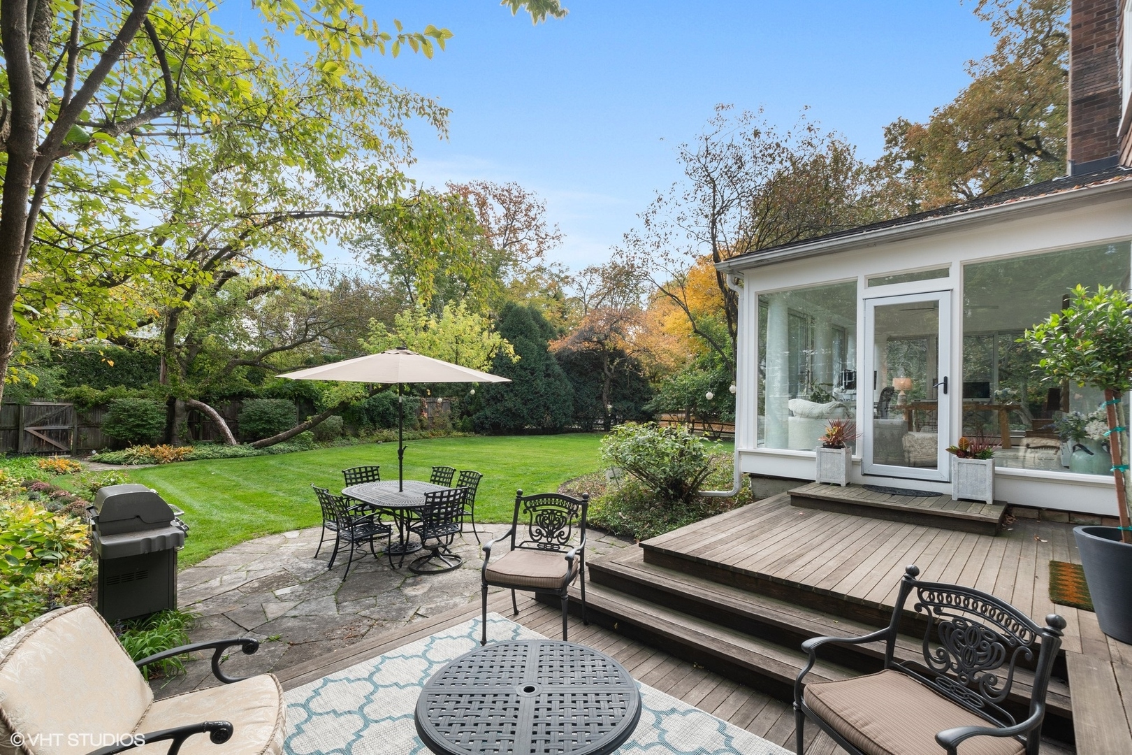 9 Warwick Road Winnetka, IL 60093 - Photo 50 of 54 a view of a patio with couches table and chairs under an umbrella with a small yard