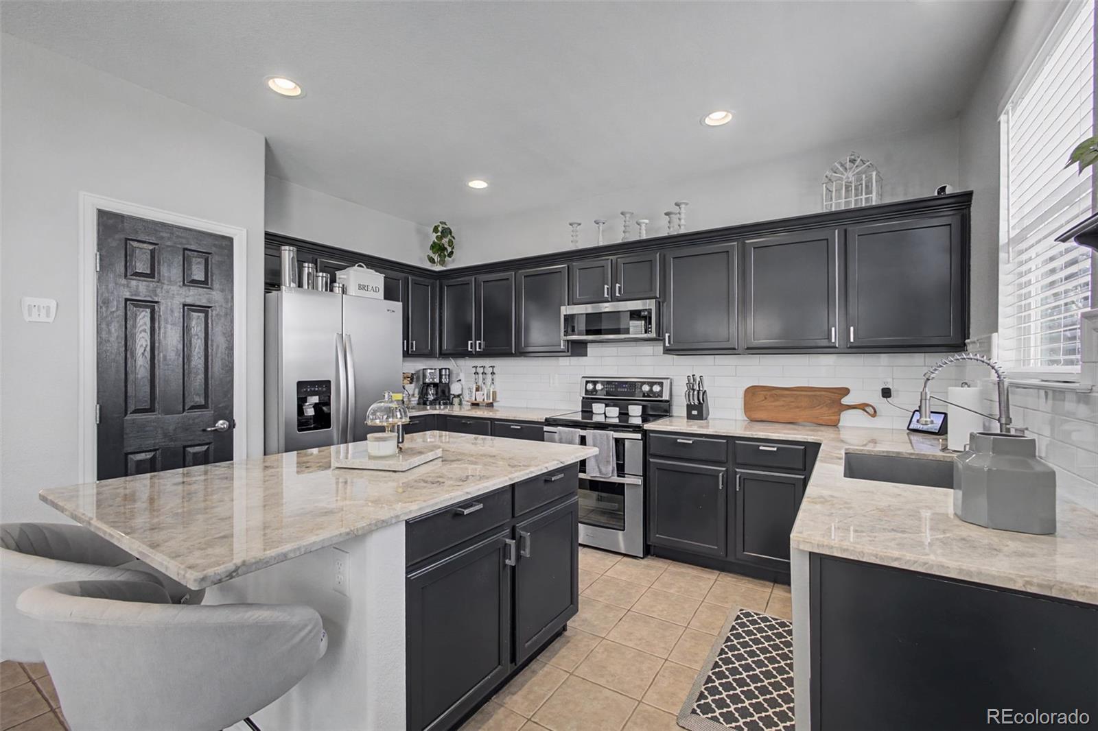 2921 Fulton Street Denver, CO 80238 - Photo 15 of 42 a kitchen with stainless steel appliances granite countertop a sink stove refrigerator and cabinets