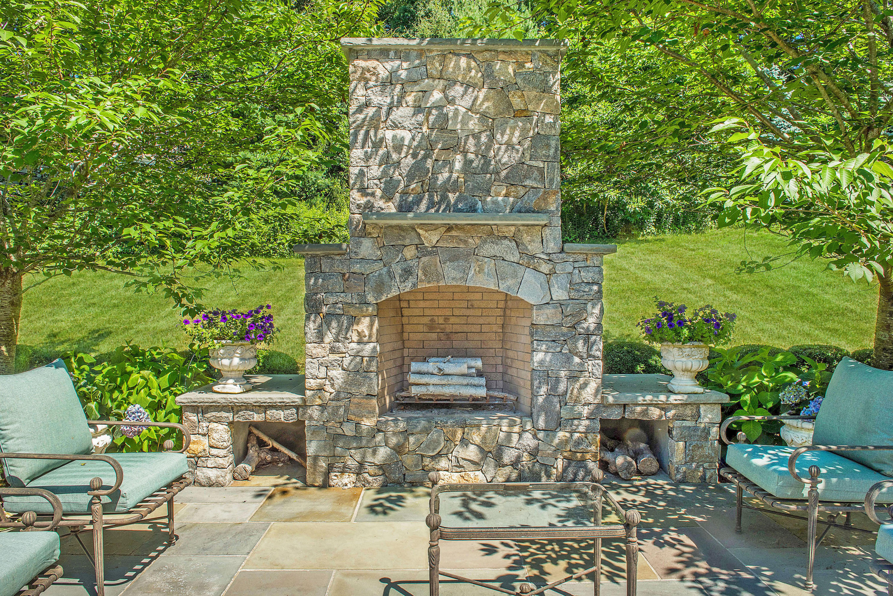 20 Silvermine Road New Canaan, CT 06840 - Photo 39 of 45 a brick building with a bench and potted plants