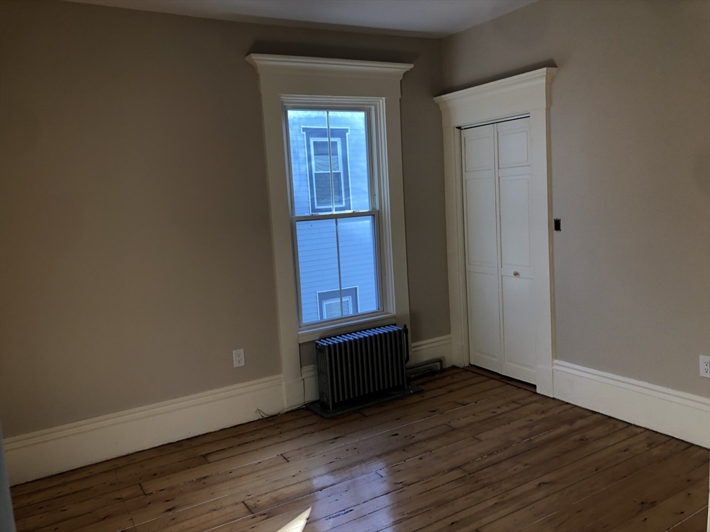 62 Thomas Street, Unit 2 New Bedford, MA 02740 - Photo 6 of 10 a view of an empty room with wooden floor and a window
