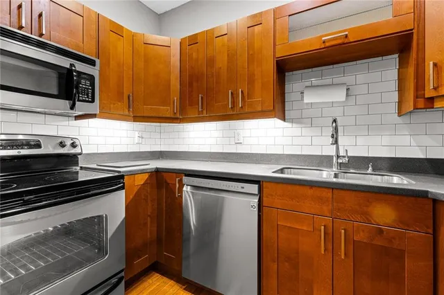 a kitchen with stainless steel appliances granite countertop a sink stove and microwave
