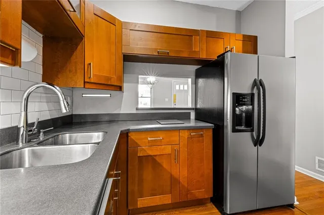 a kitchen with stainless steel appliances granite countertop a refrigerator and a sink