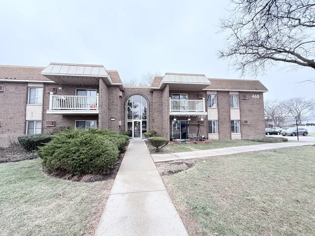 a front view of a house with a yard and potted plants