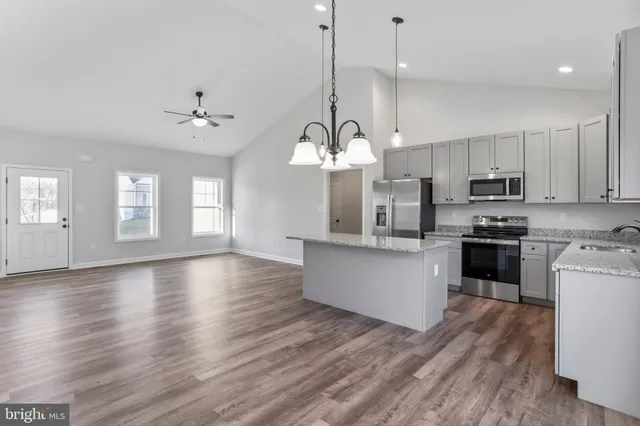 a kitchen with stainless steel appliances granite countertop a stove a sink and a refrigerator