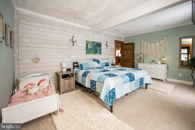 a bedroom with a bed and a dresser next to a window