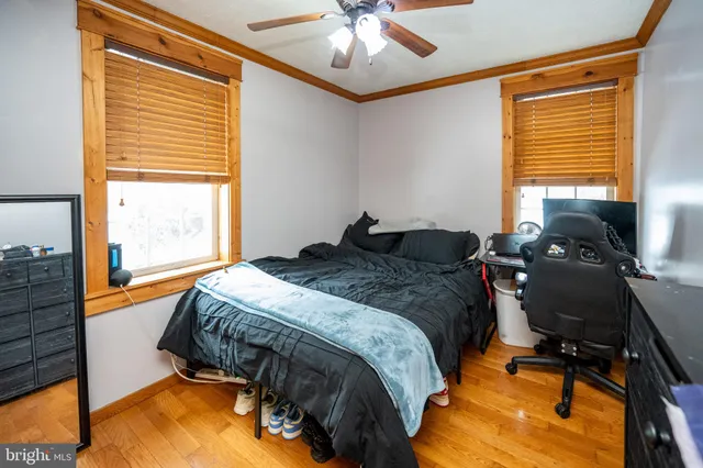 a view of a hallway with wooden floor and a bathroom