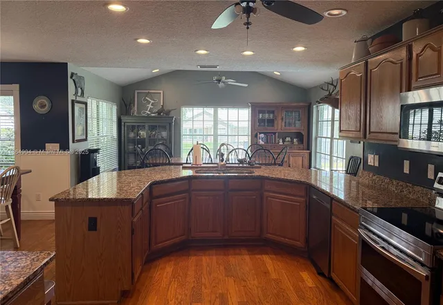 a kitchen with stainless steel appliances wooden cabinets a sink and a stove