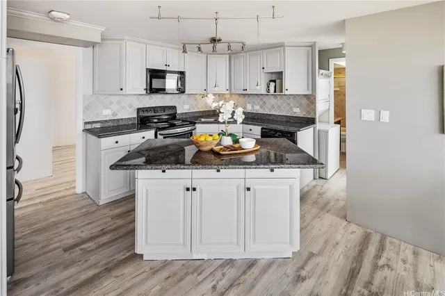 a kitchen with stainless steel appliances granite countertop a refrigerator a stove top oven a sink and dishwasher