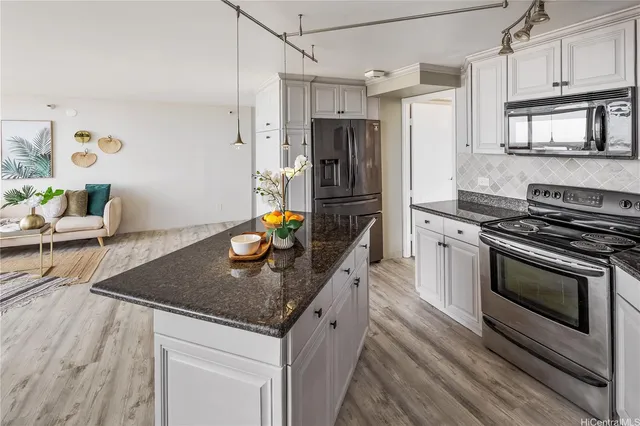 a kitchen with stainless steel appliances granite countertop a sink stove and refrigerator