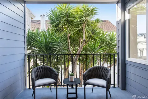 a view of balcony with a potted plant and outdoor seating