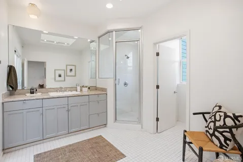 a spacious bathroom with a shower sink and mirror
