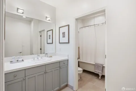 a spacious bathroom with a double vanity sink a mirror and a bathtub