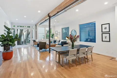 a living room with furniture a potted plant and a large window