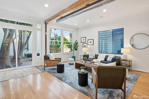 a living room with fireplace furniture and a large window