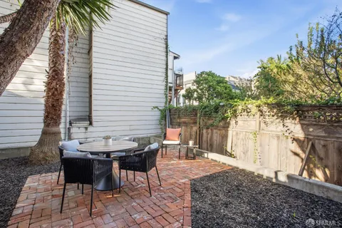 a backyard of a house with table and chairs