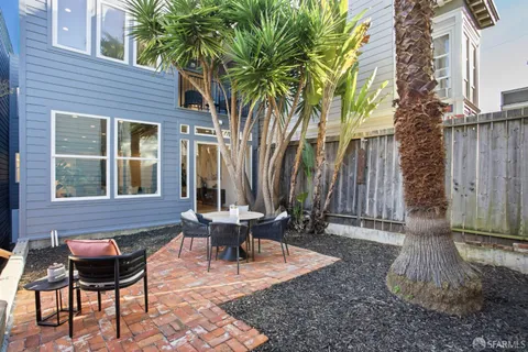 a view of a house with backyard and sitting area