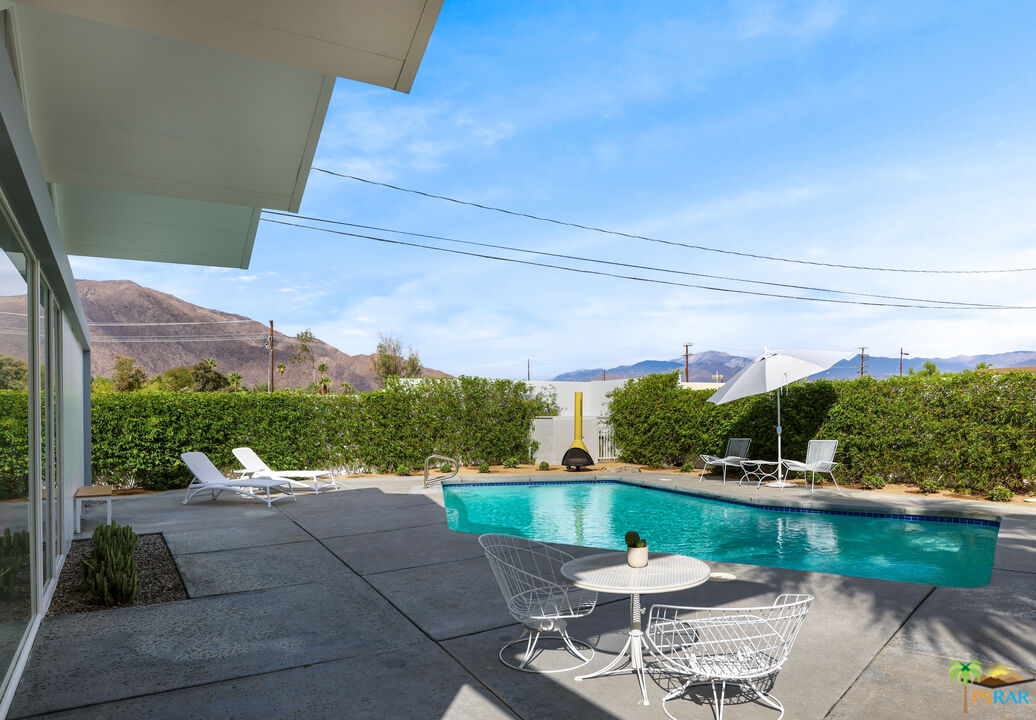 290 East Simms Road Palm Springs, CA 92262 - Photo 31 of 37 a view of a patio with table and chairs potted plants and a palm tree