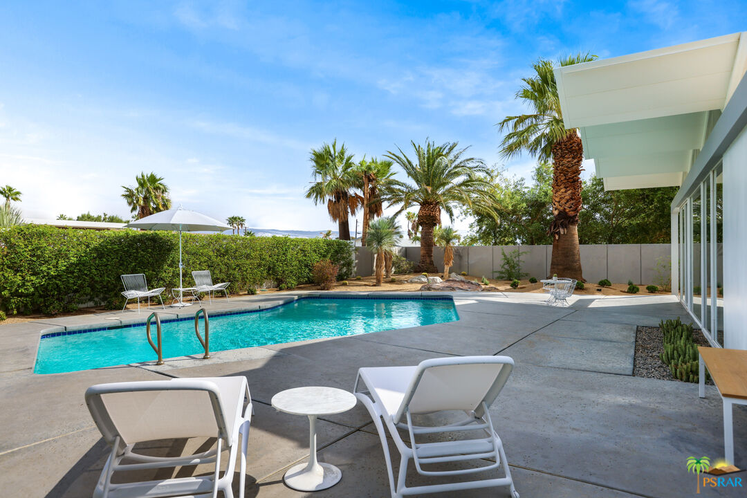 290 East Simms Road Palm Springs, CA 92262 - Photo 36 of 37 a view of a patio with table and chairs potted plants and palm tree