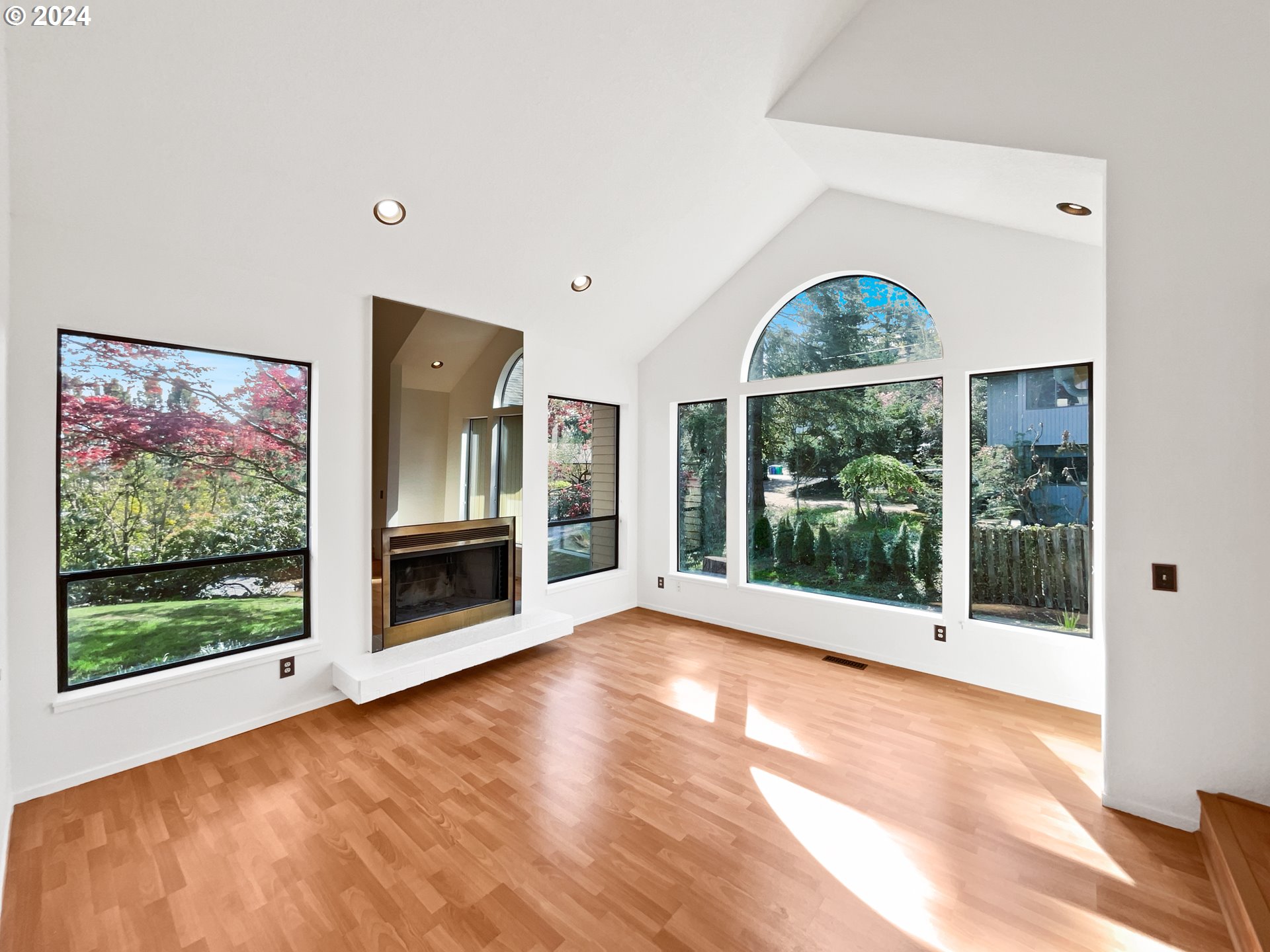 11621 Southwest 43rd Avenue Portland, OR 97219 - Photo 6 of 19 a view of an empty room with wooden floor and a fireplace