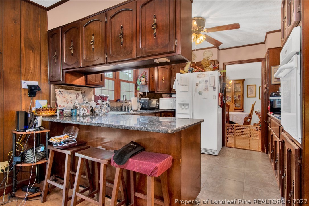 1537 Rice Road Orrum, NC 28369 - Photo 14 of 31 a kitchen with stainless steel appliances granite countertop a stove and a refrigerator