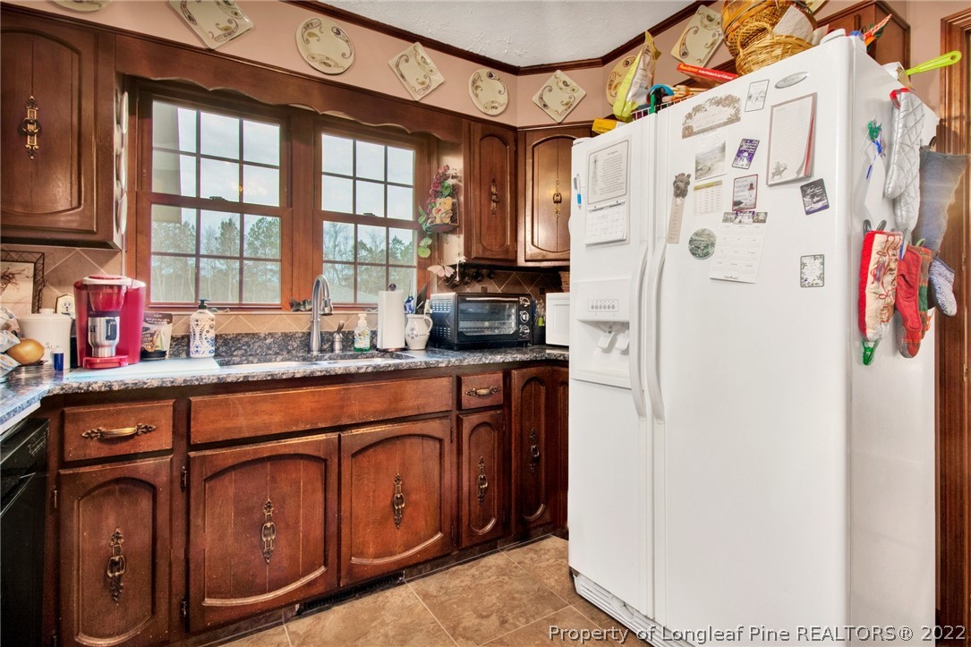 1537 Rice Road Orrum, NC 28369 - Photo 16 of 31 a kitchen with stainless steel appliances granite countertop a refrigerator and a sink