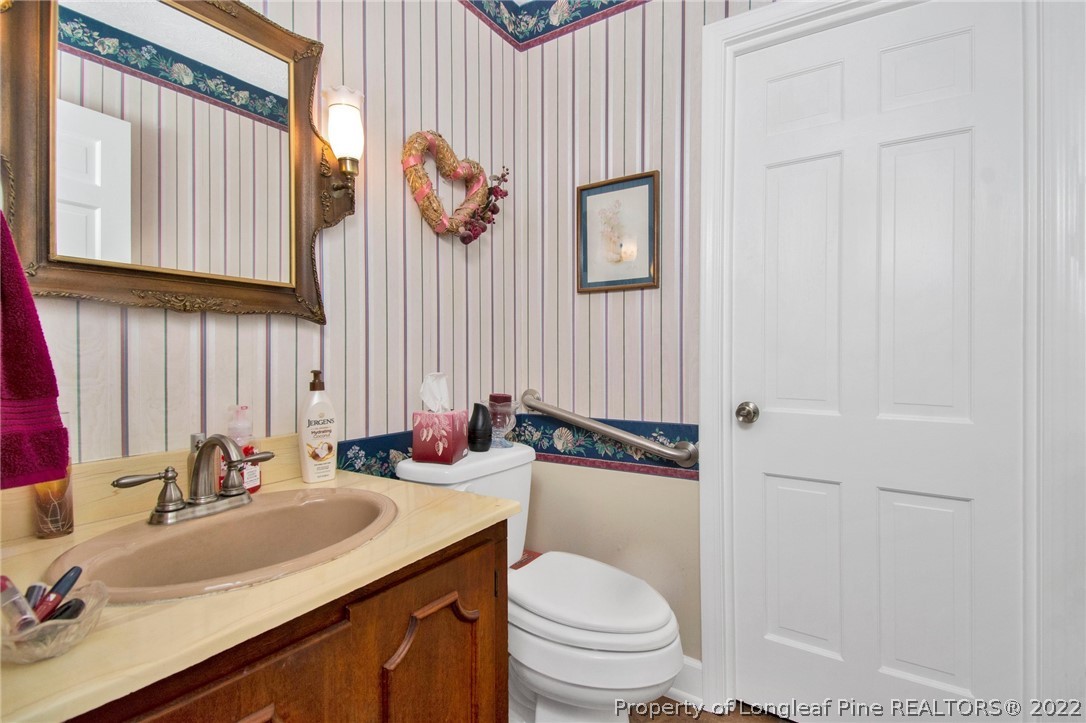 1537 Rice Road Orrum, NC 28369 - Photo 10 of 31 a bathroom with a sink a toilet and mirror